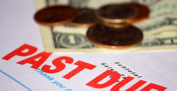 Past due bill with pennies and dollar bills