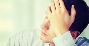 Man puts his hand to his forehead