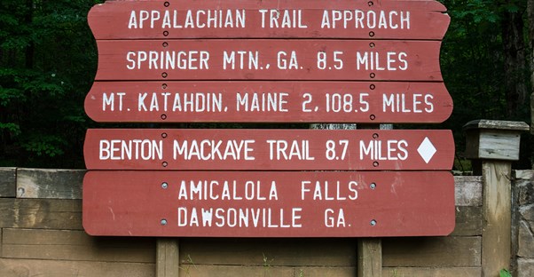 an appalachian trail marker displays distances to nearby cities