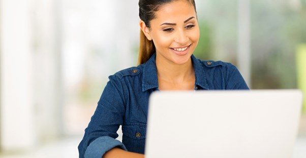 a young woman searches for the best online college on her laptop