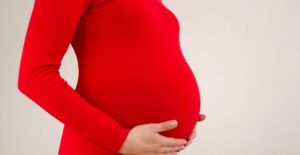 A pregnant woman dressed as a tomatoe