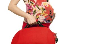 Pregnant woman taking her newly packed hospital bag to the car