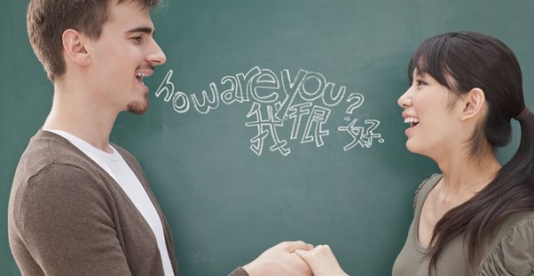 A man and a woman hold hands and speak different languages to each other