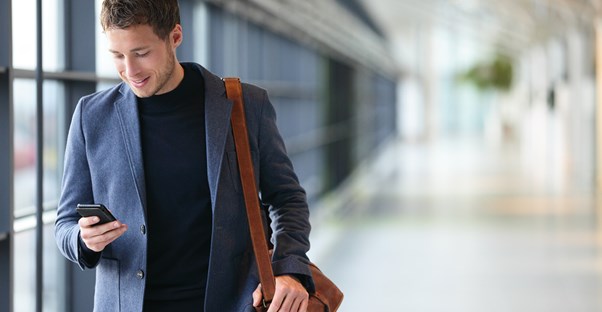 Guy looks down and smiles at his phone
