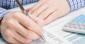 Man in Plaid Shirt Signing Paperwork
