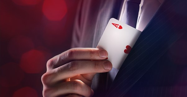 a branson magician slips a card into his front coat pocket