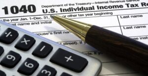 Calculator, pen, and tax form. Perfect trifecta.