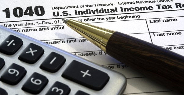 Calculator, pen, and tax form. Perfect trifecta.
