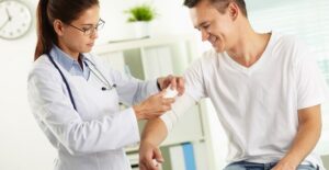 Man having his arm bandaged by a doctor
