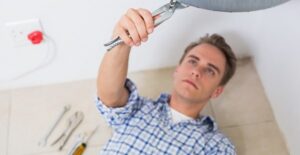 A man tends to his tankless water heater so it works properly