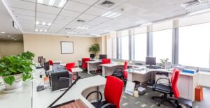 An office with red chairs at each cubicle