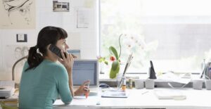 Girl talks on her phone in her office