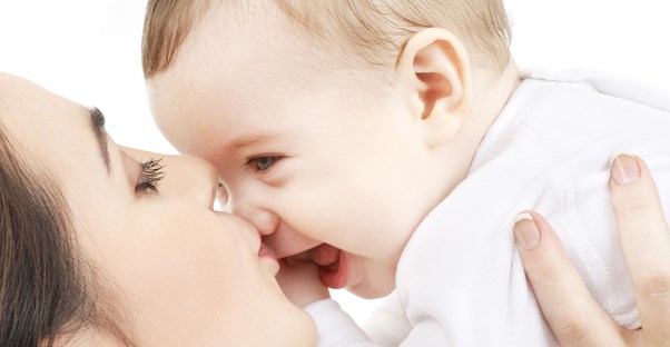Mom playing with her baby to distract it from breastfeeding