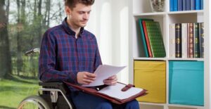 Man reading papers in a wheel chair