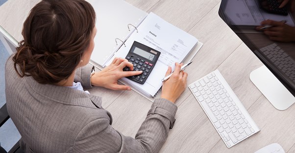 Accountant types on her calculator