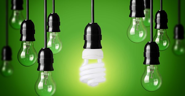 An energy efficient light bulb hanging up among regular light bulbs