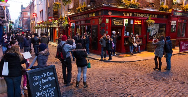 patrons crowd around the namesake of dublin's temple bar area