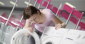 Woman investigates a front loading washing machine