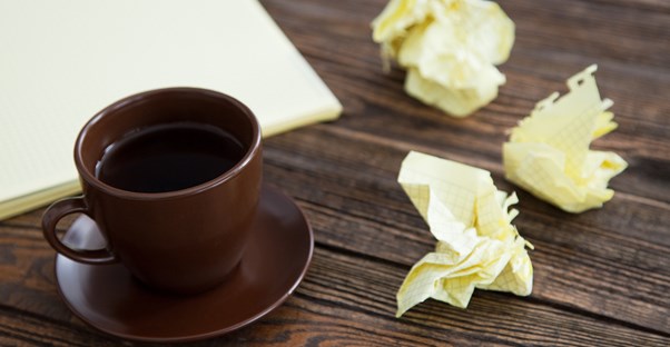 Cup of coffee with a side of crumpled notebook paper