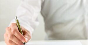 Man writes with a tiny pen