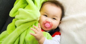 A baby smiling with a pacifier