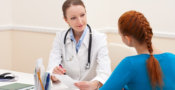 a woman discussing psoriasis with her dermatologist