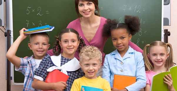 A teacher hugs her students