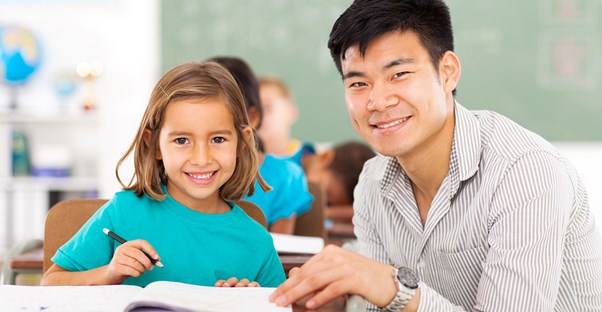 A teacher helps a student with her work