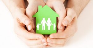 Family holding a tiny house representative of it's equity