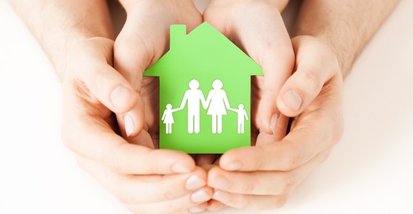 Family holding a tiny house representative of it's equity