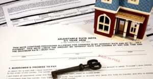Miniature home and key on top of home equity loan paperwork