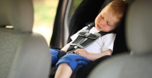 Little boy secured in his car seat