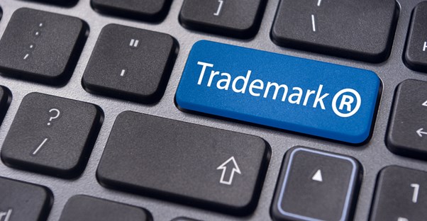 A keyboard with a blue key that says trademark