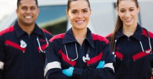 A team of EMTs stand and smile after a job well done