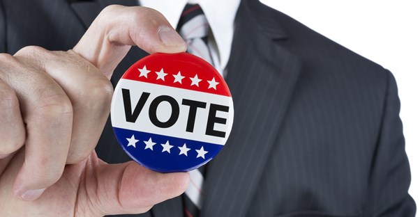 Man proudly shows off his voting pin