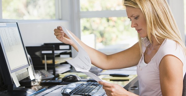 A woman frantically searching for a document in an unorganized office
