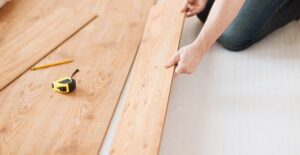 A woman installing a new floor to invest in her home