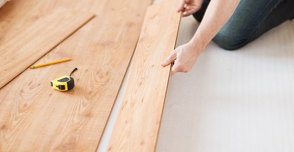 A woman installing a new floor to invest in her home