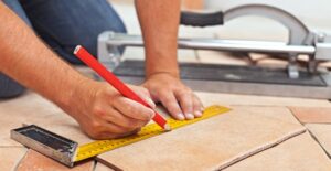 Man measuring out tile for his bathroom