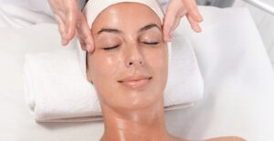 A woman enjoys a facial from an esthetician