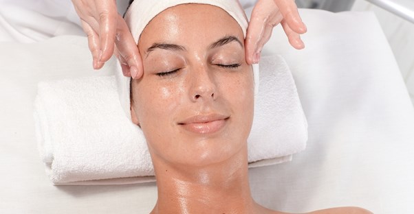 A woman enjoys a facial from an esthetician