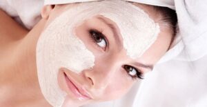 A woman smiles carefully as to not crack her face mask