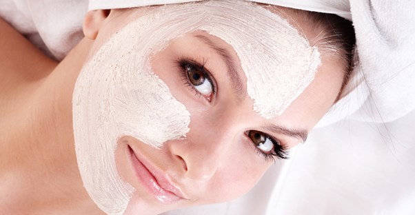 A woman smiles carefully as to not crack her face mask