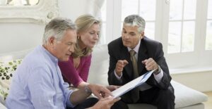 A life coach goes over some paperwork with an older couple