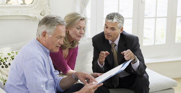 A life coach goes over some paperwork with an older couple