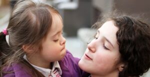 A nanny hugs a little girl