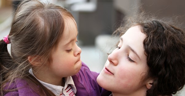 A nanny hugs a little girl