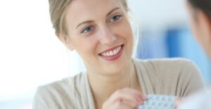 a woman picking up her oral contraceptives