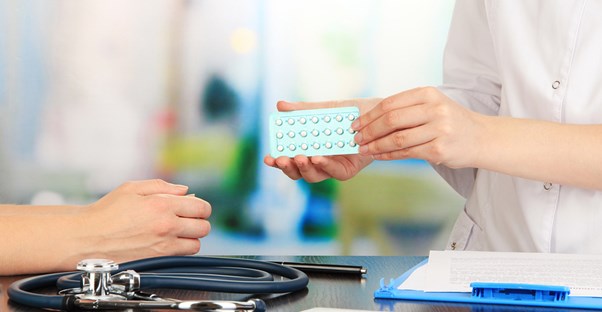 a woman holding contraceptives