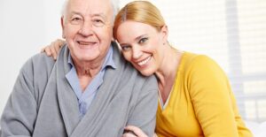 A social worker hugs an elderly man